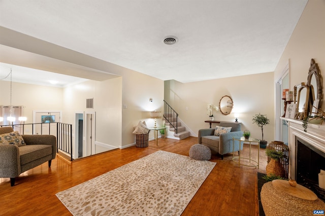 147 Scarborough Pl, Charlottesville, VA 22903 - living area featuring wood finished floors, a chandelier, stairs, and a fireplace