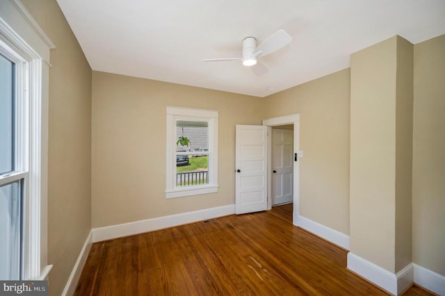 spare room featuring ceiling fan, baseboards, and wood finished floors