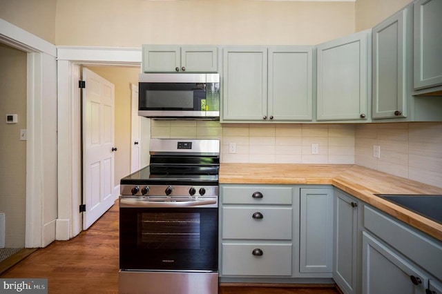 kitchen with decorative backsplash, stainless steel appliances, and wooden counters