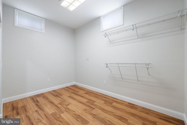  - walk in closet with light wood finished floors