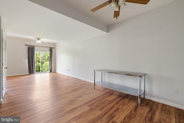 - unfurnished room with ceiling fan, wood finished floors, and baseboards