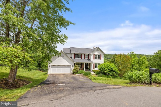  - traditional home featuring asphalt driveway, a front lawn, covered porch, and an attached garage