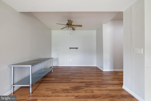  - empty room featuring a ceiling fan, wood finished floors, and baseboards