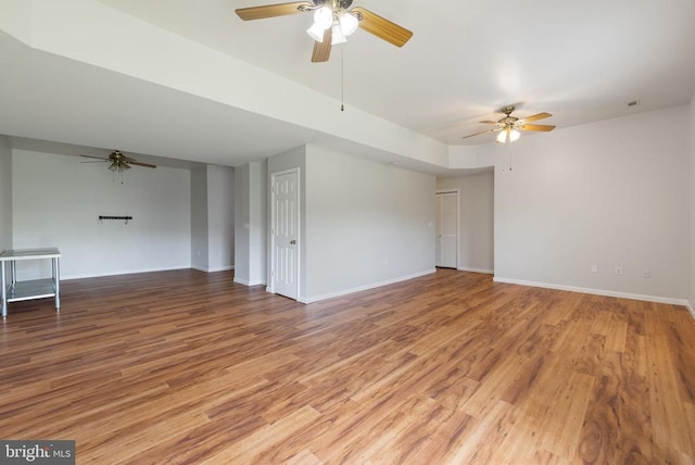  - unfurnished room with ceiling fan, light wood-style flooring, and baseboards
