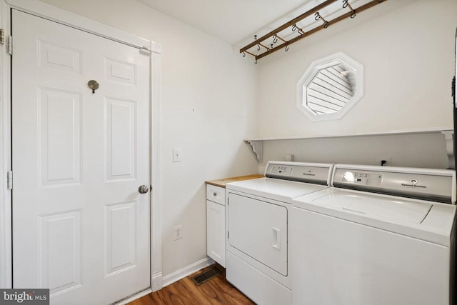  - laundry area featuring washing machine and clothes dryer, cabinet space, dark wood-type flooring, and baseboards