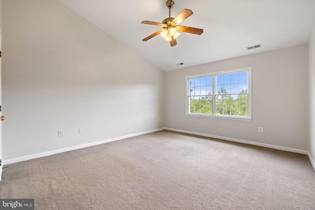  - carpeted empty room with vaulted ceiling, a ceiling fan, and baseboards