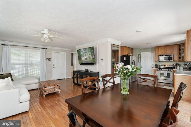 5008 Blake Dr, Fredericksburg, VA 22407 - dining space featuring a ceiling fan, light wood-style floors, crown molding, and a textured ceiling