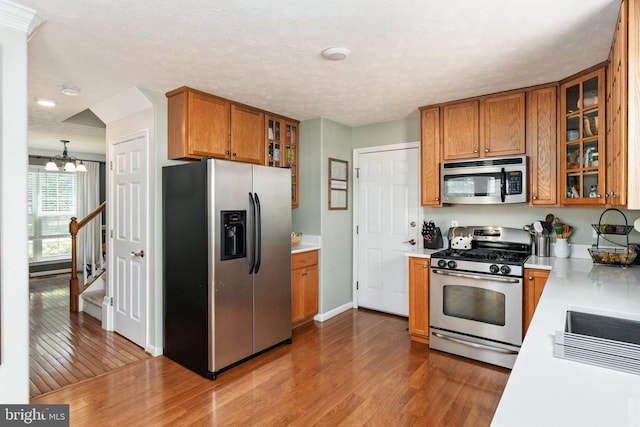 5008 Blake Dr, Fredericksburg, VA 22407 - kitchen with stainless steel appliances, brown cabinets, light countertops, wood finished floors, and a textured ceiling