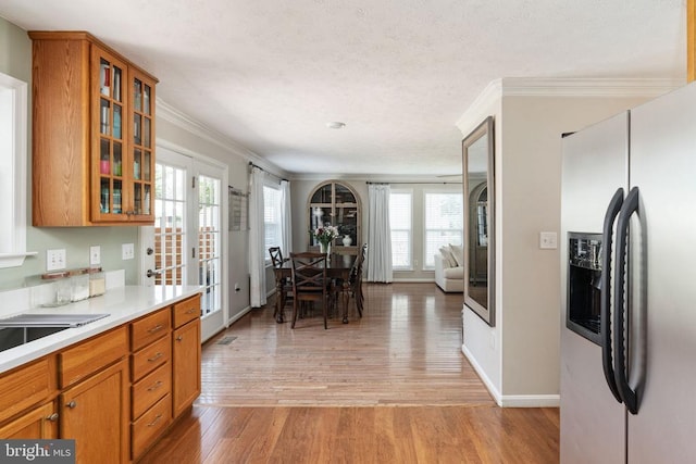 5008 Blake Dr, Fredericksburg, VA 22407 - kitchen with stainless steel fridge, light wood-style floors, brown cabinets, and ornamental molding