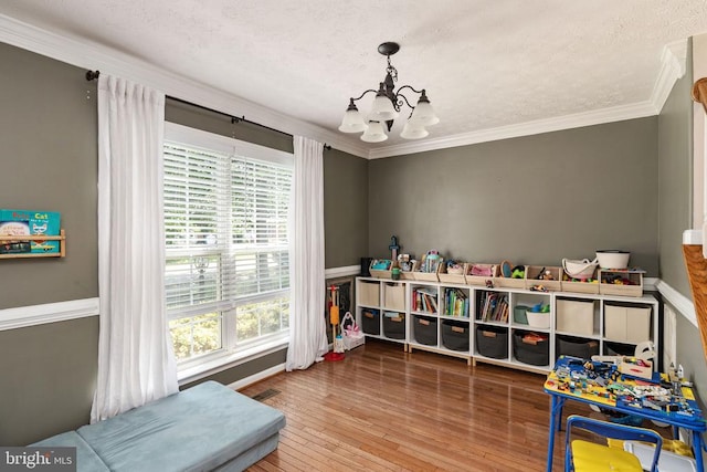 5008 Blake Dr, Fredericksburg, VA 22407 - recreation room featuring a chandelier, crown molding, hardwood / wood-style flooring, and a textured ceiling