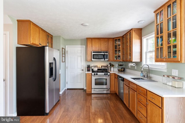 5008 Blake Dr, Fredericksburg, VA 22407 - kitchen with stainless steel appliances, dark wood finished floors, brown cabinets, light countertops, and glass insert cabinets