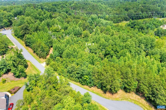 birds eye view of property featuring a view of trees