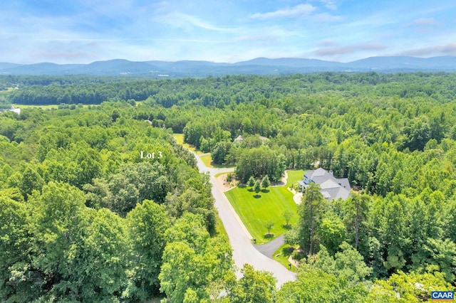 drone / aerial view featuring a mountain view and a view of trees