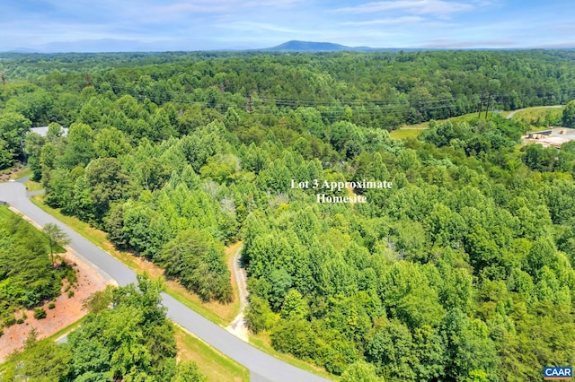 drone / aerial view featuring a wooded view