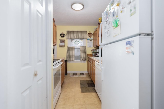 310 Spotswood Ave E, Elkton, VA 22827 - kitchen featuring white appliances, light countertops, brown cabinets, light tile patterned floors, and a textured ceiling