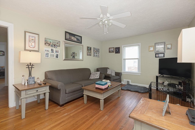 310 Spotswood Ave E, Elkton, VA 22827 - living area with light wood-style flooring, a ceiling fan, a textured ceiling, and baseboards