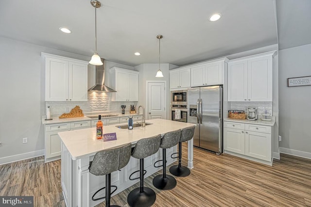 5220 Wyndemere Cir, Mineral, VA 23117 - kitchen with appliances with stainless steel finishes, a sink, baseboards, wall chimney range hood, and decorative backsplash