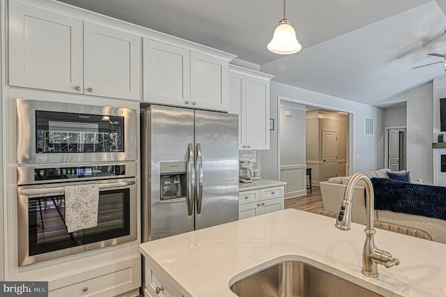5220 Wyndemere Cir, Mineral, VA 23117 - kitchen with stainless steel appliances, a sink, white cabinetry, light stone countertops, and hanging light fixtures