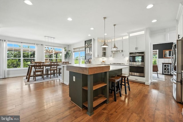 10901 Brandermill Park, Spotsylvania, VA 22551 - kitchen with open shelves, appliances with stainless steel finishes, light countertops, an island with sink, and decorative backsplash
