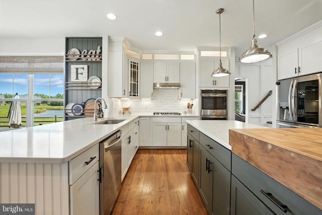 10901 Brandermill Park, Spotsylvania, VA 22551 - kitchen with appliances with stainless steel finishes, backsplash, hanging light fixtures, white cabinetry, and wood finished floors
