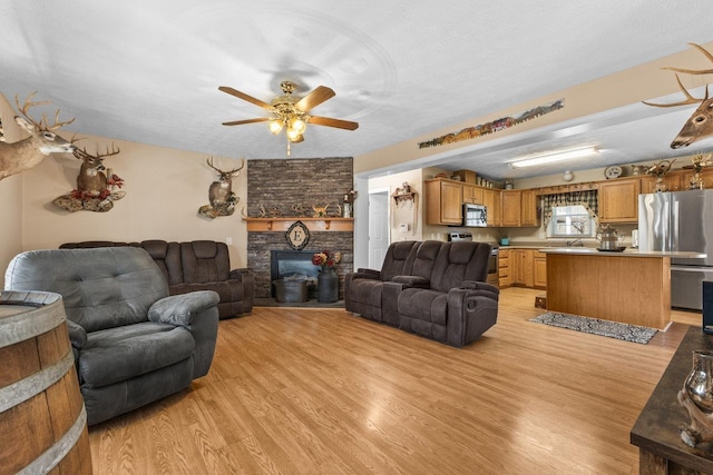 18785 Red Brush Rd, Elkton, VA 22827 - living room with a ceiling fan, a stone fireplace, and light wood-style flooring