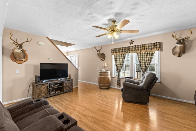 18785 Red Brush Rd, Elkton, VA 22827 - living room featuring ceiling fan, a textured ceiling, baseboards, and light wood-style floors