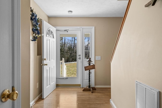 18785 Red Brush Rd, Elkton, VA 22827 - entryway featuring light wood-type flooring, visible vents, baseboards, and a textured ceiling