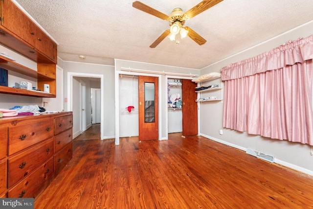 234 Landon Ln, Orange, VA 22960 - unfurnished bedroom with wood finished floors, a textured ceiling, baseboards, two closets, and a ceiling fan