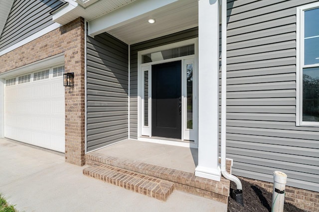 4125 Romney Ct, Rockingham, VA 22802 - property entrance with a garage, brick siding, and concrete driveway