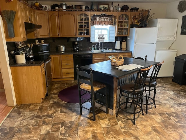 290 Shenandoah River Rd, Shenandoah, VA 22849 - kitchen featuring under cabinet range hood, a sink, stacked washer and dryer, black appliances, and dark countertops