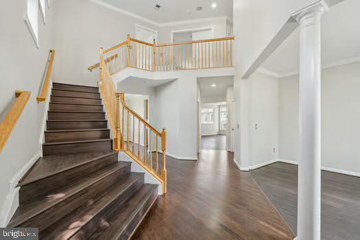 1025 Riverdale Cir, Culpeper, VA 22701 - staircase with ornate columns, wood finished floors, and ornamental molding