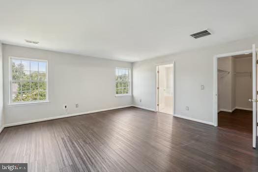 1025 Riverdale Cir, Culpeper, VA 22701 - unfurnished bedroom with a walk in closet, dark wood finished floors, a closet, and connected bathroom