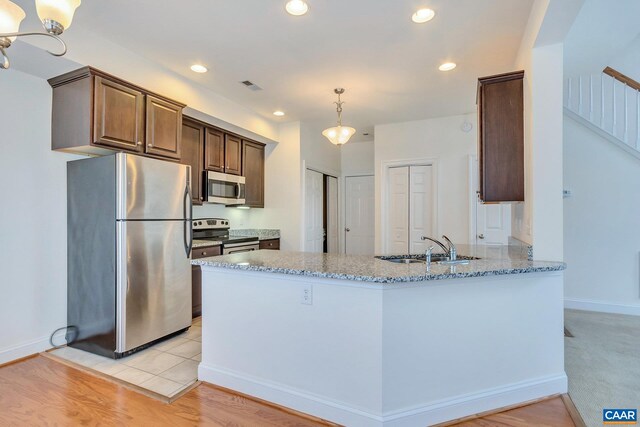 kitchen featuring a sink, visible vents, appliances with stainless steel finishes, light stone counters, and recessed lighting