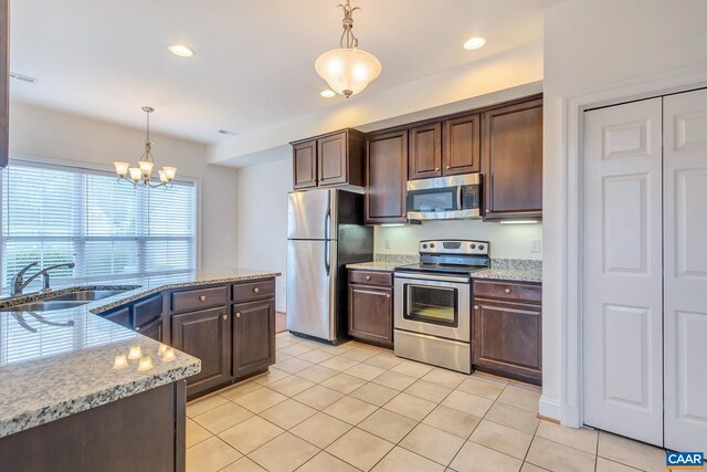 kitchen with a chandelier, stainless steel appliances, dark brown cabinets, and a sink