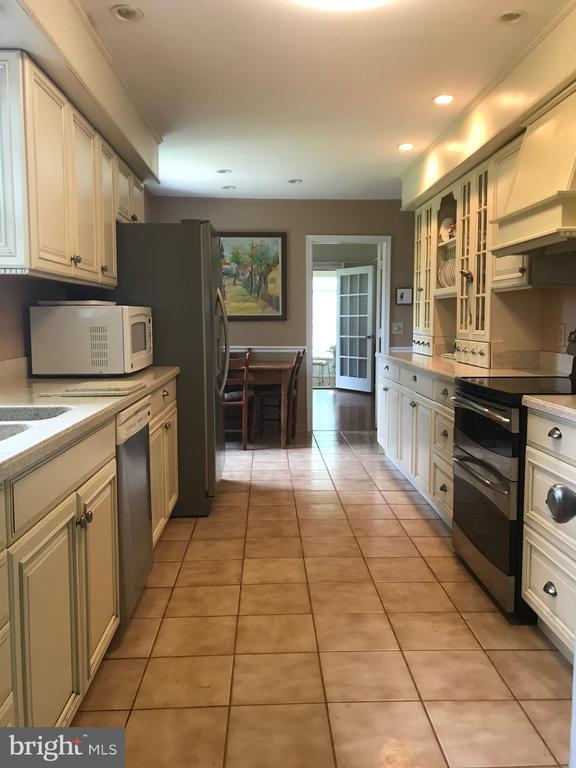 409 Cook Mountain Dr, Brightwood, VA 22715 - kitchen featuring stainless steel appliances, custom range hood, light countertops, light tile patterned flooring, and glass insert cabinets