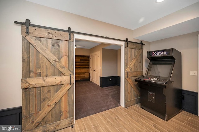 11001 Waterstone Pl, Spotsylvania, VA 22551 - unfurnished bedroom featuring a barn door, wood finished floors, a wainscoted wall, and recessed lighting