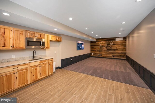 11001 Waterstone Pl, Spotsylvania, VA 22551 - kitchen featuring stainless steel microwave, a sink, recessed lighting, wooden walls, and light wood finished floors