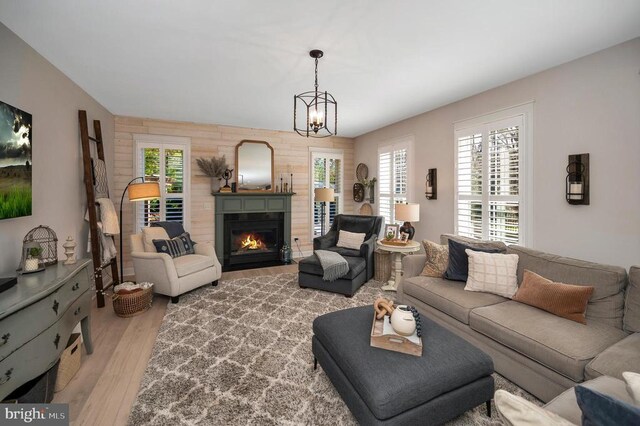 11001 Waterstone Pl, Spotsylvania, VA 22551 - living area with wood finished floors, a fireplace with flush hearth, and a chandelier