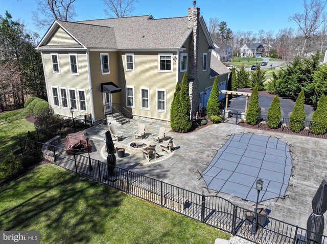 11001 Waterstone Pl, Spotsylvania, VA 22551 - back of house featuring a fire pit, a patio, a chimney, entry steps, and roof with shingles