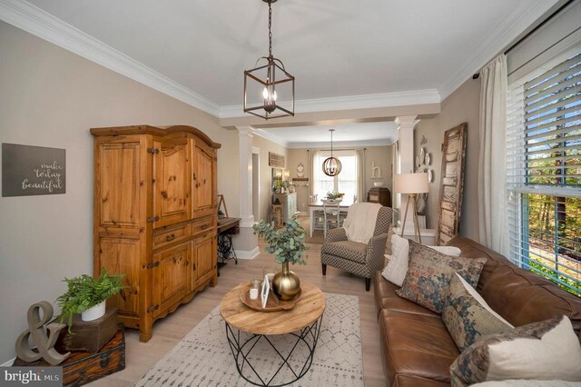 11001 Waterstone Pl, Spotsylvania, VA 22551 - living room featuring decorative columns, a chandelier, light wood finished floors, crown molding, and baseboards