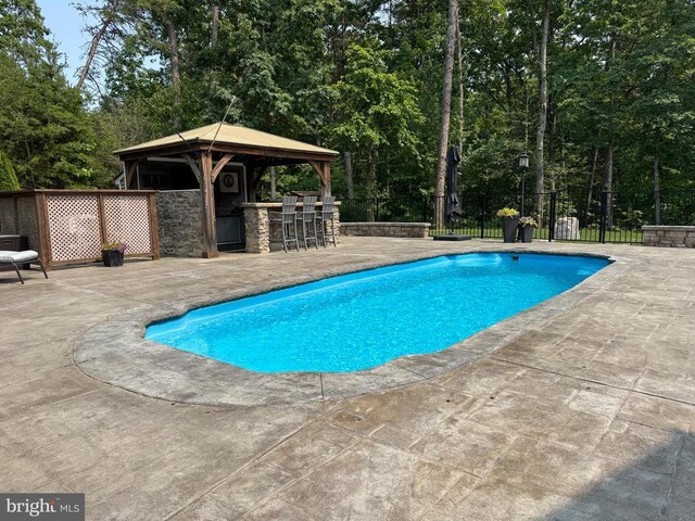 11001 Waterstone Pl, Spotsylvania, VA 22551 - swimming pool with a patio, a gazebo, and view of wooded area