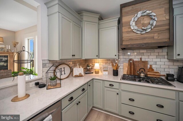 11001 Waterstone Pl, Spotsylvania, VA 22551 - kitchen featuring stainless steel gas stovetop, tasteful backsplash, light stone counters, gray cabinetry, and light wood-style flooring