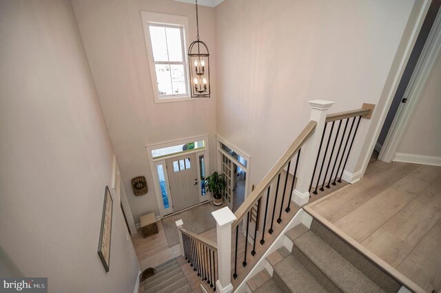 11001 Waterstone Pl, Spotsylvania, VA 22551 - foyer entrance with a chandelier, stairway, a towering ceiling, wood finished floors, and baseboards