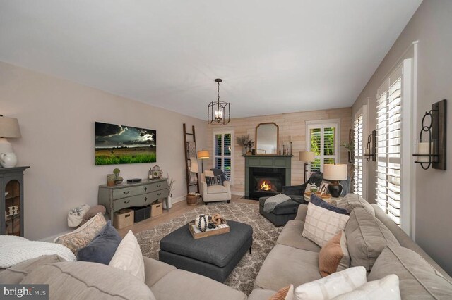 11001 Waterstone Pl, Spotsylvania, VA 22551 - living area featuring a fireplace with flush hearth, wood finished floors, a chandelier, and baseboards