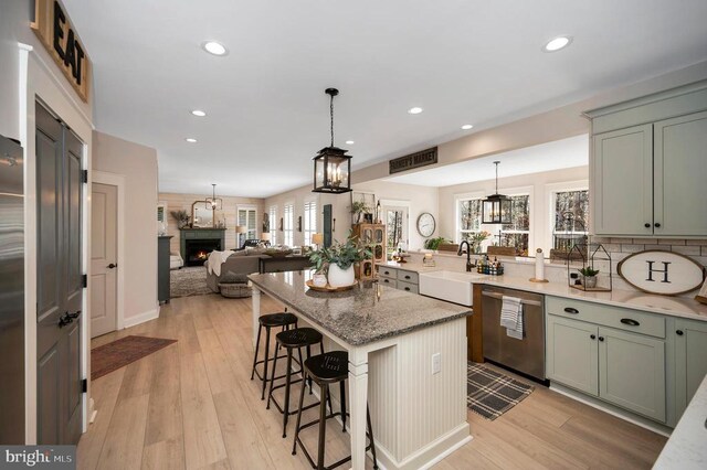 11001 Waterstone Pl, Spotsylvania, VA 22551 - kitchen featuring stainless steel dishwasher, a sink, a kitchen breakfast bar, recessed lighting, and light wood-style floors