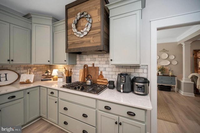 11001 Waterstone Pl, Spotsylvania, VA 22551 - kitchen with ornate columns, tasteful backsplash, light wood-style floors, crown molding, and stainless steel gas cooktop