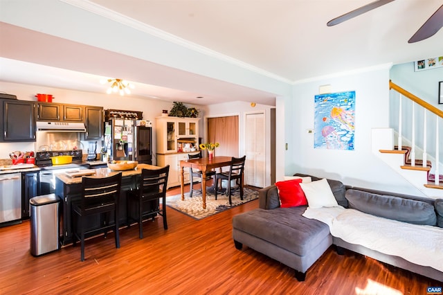 living area featuring ceiling fan, stairway, crown molding, and light wood-style floors