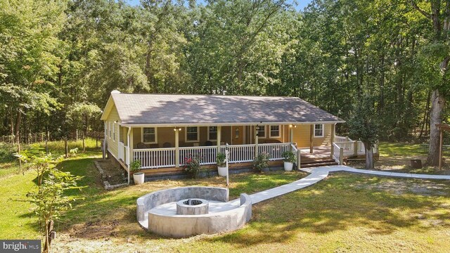31055 Lumber Rd, Locust Grove, VA 22508 - view of front of property with a porch, a fire pit, a front yard, and a forest view