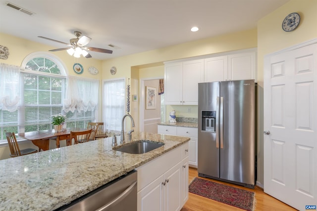 5031 Clearfields Ct, Crozet, VA 22932 - kitchen with appliances with stainless steel finishes, ceiling fan, light wood-type flooring, white cabinets, and light stone counters