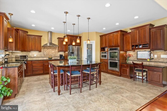 7610 Downstream Ct, Fredericksburg, VA 22408 - kitchen featuring wall chimney exhaust hood, stainless steel appliances, a sink, a breakfast bar area, and recessed lighting